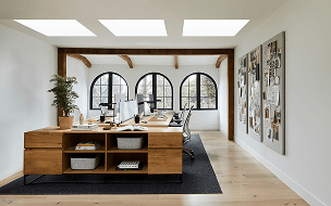 Three Velux skylights brightening a modern office studio with wooden desks