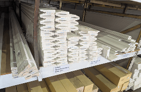 Stacked Tru-Pine primed H3 timber decorative moulding profiles on warehouse shelving